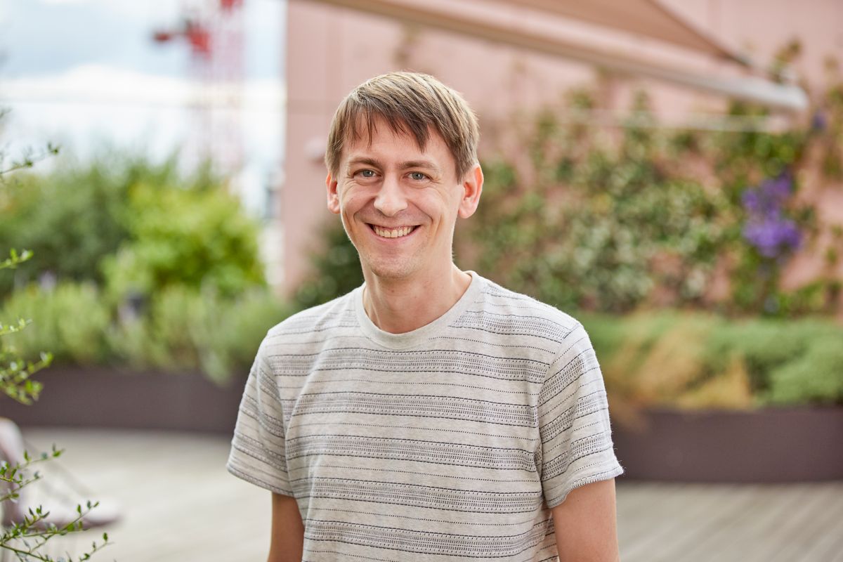 Headshot of John Jumper. He smiles at the camera and is wearing a striped shirt. Headshot of John Jumper. He smiles at the camera and is wearing a striped shirt.