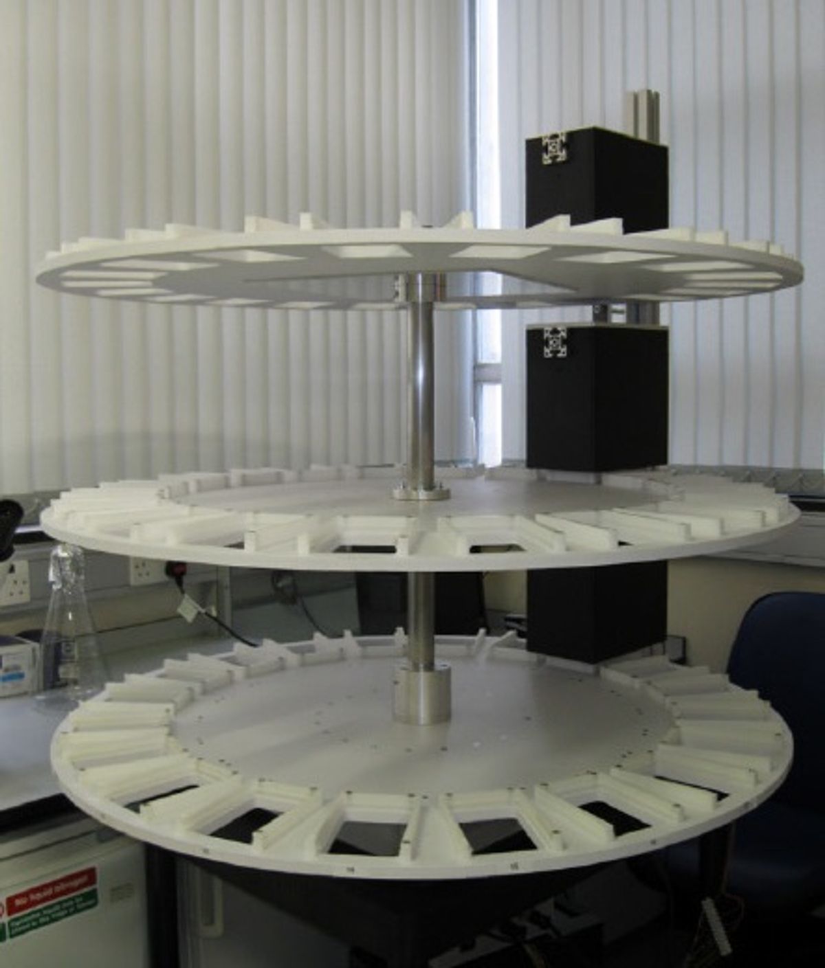 A plastic contraption with 3 tiers for holding 96-well plates. A plastic contraption with 3 tiers for holding 96-well plates.