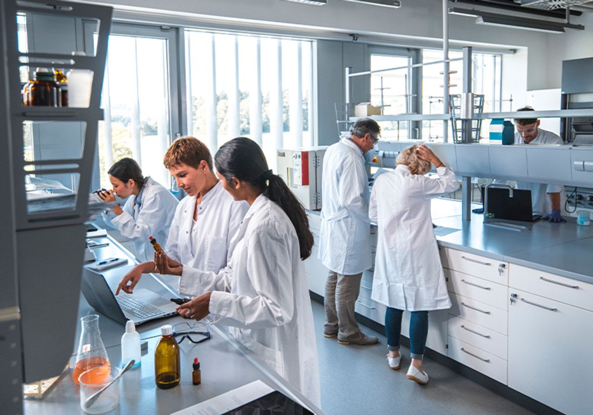 Six researchers wearing lab coats at work in the laboratory Six researchers wearing lab coats at work in the laboratory