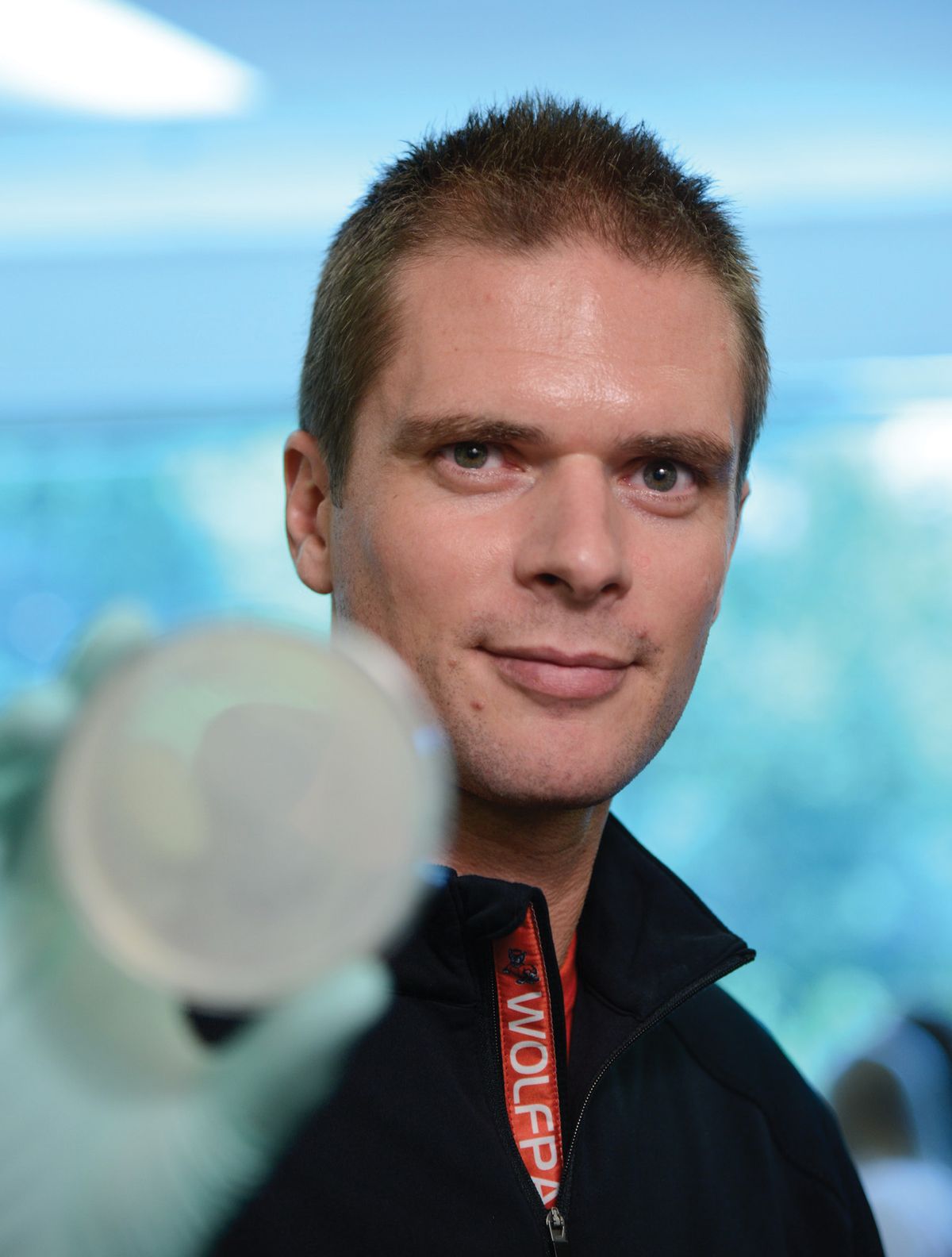 A man wears a black jacket and looks at the camera. He is holding a culture dish with his hand. A man wears a black jacket and looks at the camera. He is holding a culture dish with his hand.