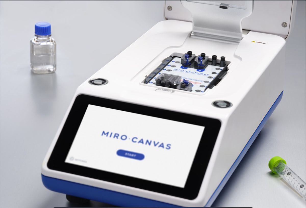 Image of a laboratory next generation sequencing automated instrument in white, blue, and black, on a lab bench background. Image of a laboratory next generation sequencing automated instrument in white, blue, and black, on a lab bench background.